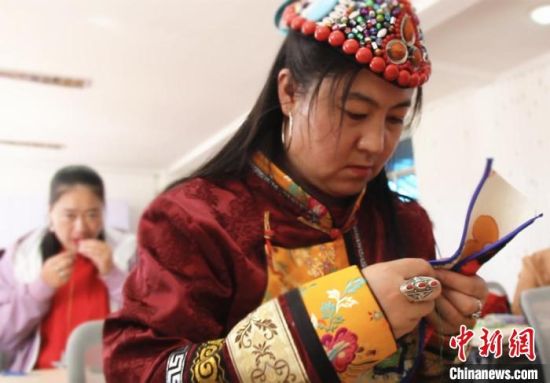 圖為裕固族婦女學(xué)習(xí)刺繡?！∈缝o靜 攝