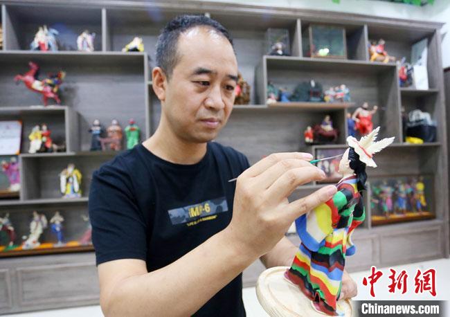 圖為安秋平正在創(chuàng)作代表隴南文縣民俗的《白馬人》作品?！「哒?攝