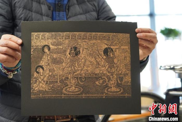 圖為手工書(shū)藝人展示敦煌雕版壁畫(huà)印刷品。　九美旦增 　攝