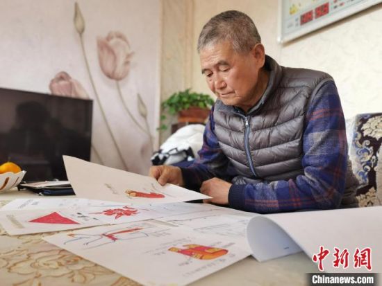 圖為陸鵬飛向記者展示多年帶隊(duì)的手寫筆記?！堟?攝