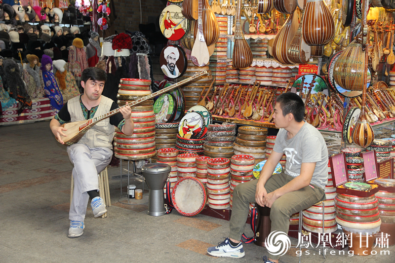 烏魯木齊二道橋巴扎內(nèi)，店主正在向客人展示樂器。楊文遠(yuǎn) 攝