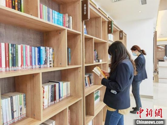 圖為在甘肅公航旅建設(shè)集團(tuán)有限公司的職工書屋，職工挑選書籍。　徐雪 攝