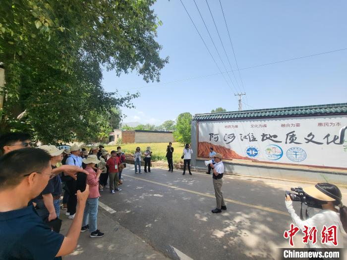 圖為中國地質(zhì)大學(xué)(北京)教授張緒教介紹村落情況?！『衍?攝