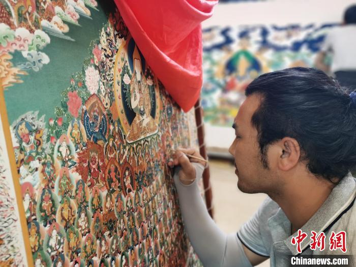 圖為更登才讓的徒弟繪畫唐卡?！?zhí)砀?攝