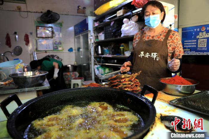 圖為平安驛·河湟民俗文化體驗(yàn)地內(nèi)的商戶炸干板魚(yú)?！⊙Φ?攝