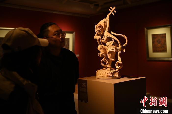 圖為季茂杰向參觀者介紹自己創(chuàng)作敦煌木雕的過程。李亞龍 攝</p>
<p>